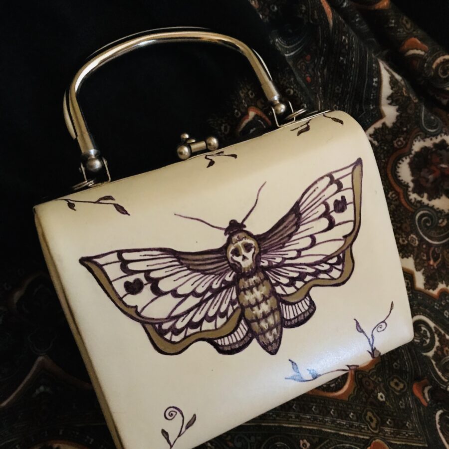 Hand drawn butterfly on a vintage handbag