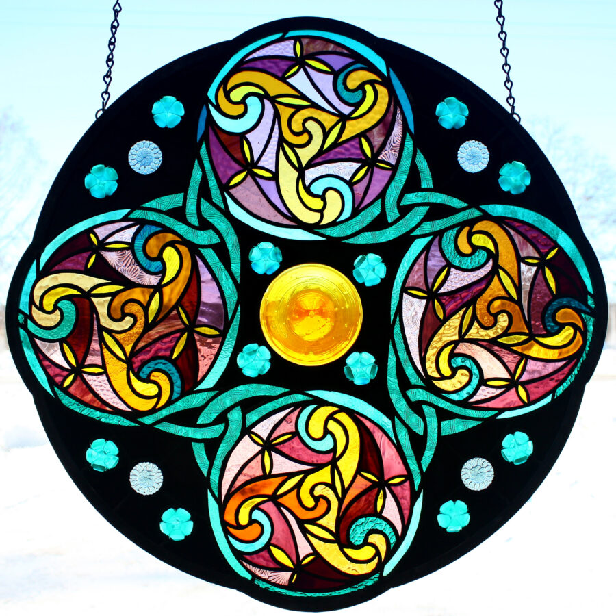 Perpetual Motion A tribute to order and forward motion amber glass is associated with energy and teal with order and calm. The perpetual motion captured by this rose window moves us forward while providing a sense of grounding and peace.