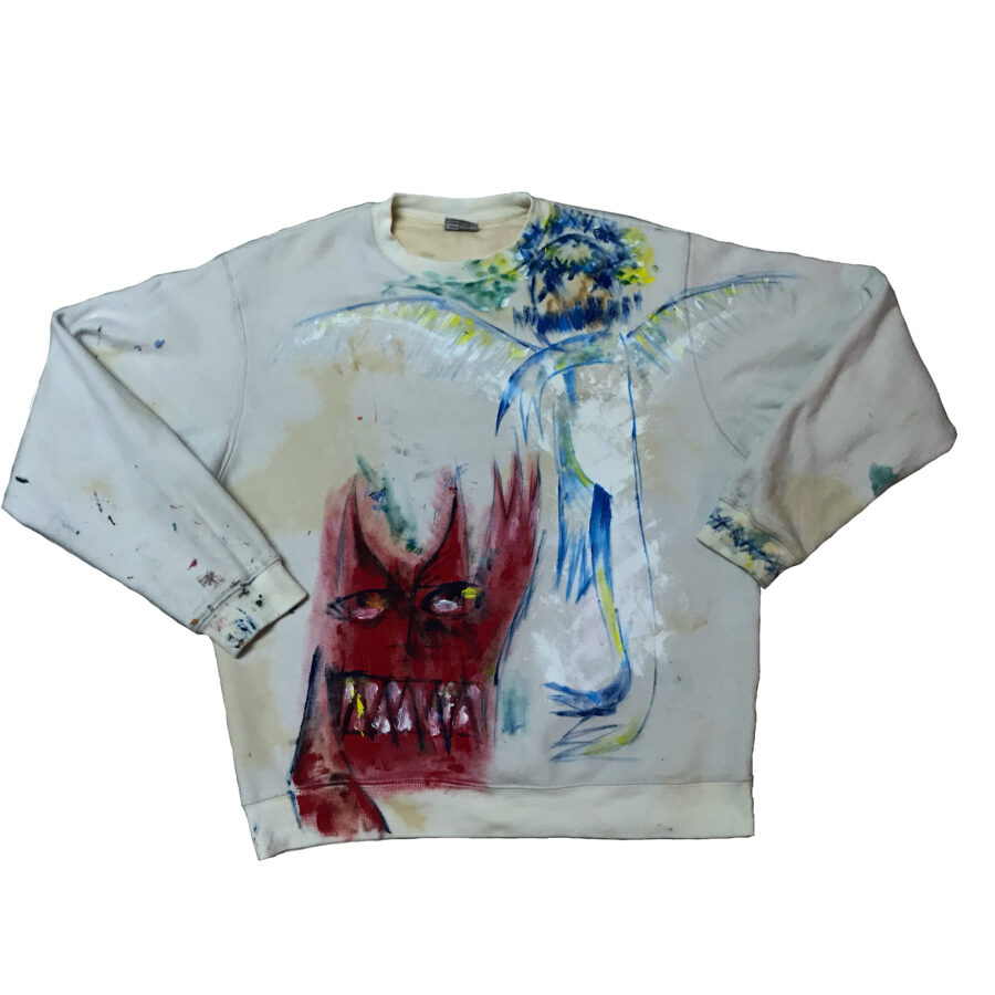 a stylized demon and angel painted on a beige crewneck sweater