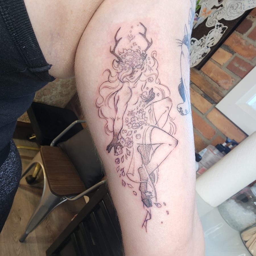 Tattoo of a deer nymph with flowers falling into their lap