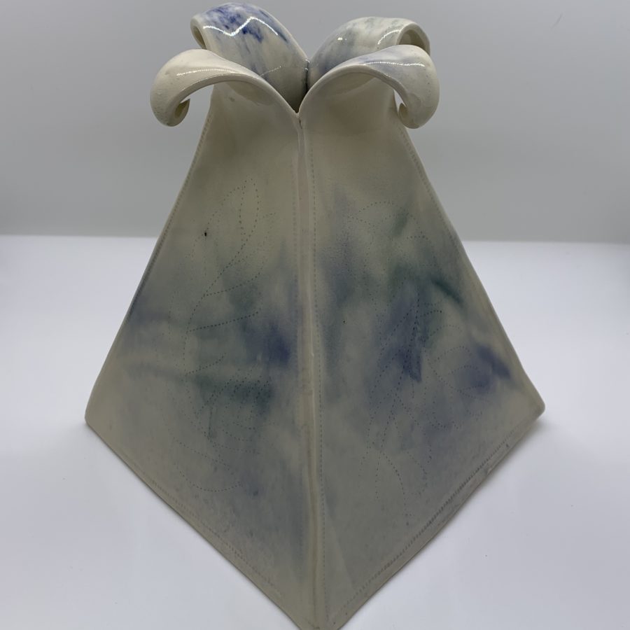 White clay pyramid-shaped vase with petal-shaped opening. Watercolour-style blue, green, and clear glaze cover the quilt-style incising. 