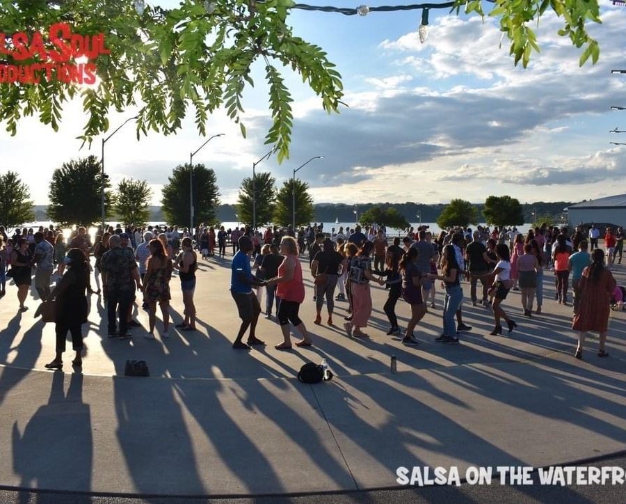 A large crowd of diverse people participating in the dance lesson at Salsa on the Waterfront on the skating rink at Pier 8 in Hamilton.