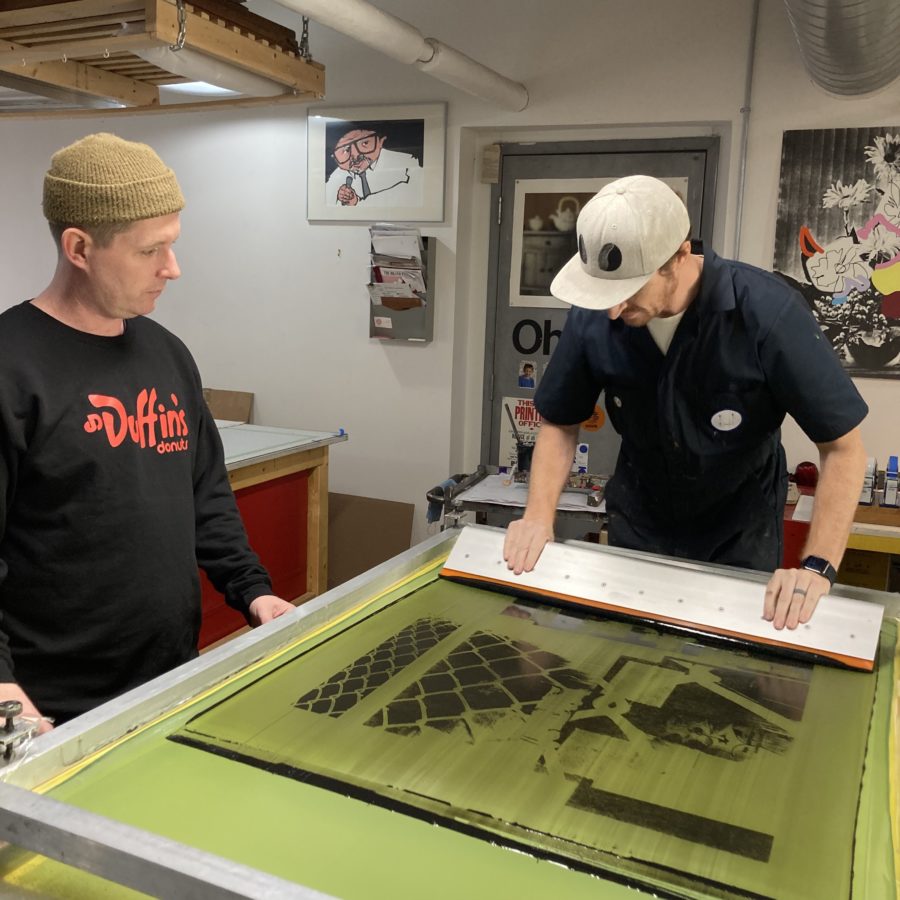 Artist Niall McClelland and Smokestack Analog Printmaker, Laine Groeneweg, pulling silkscreens in the Smokestack Studio, 2023 