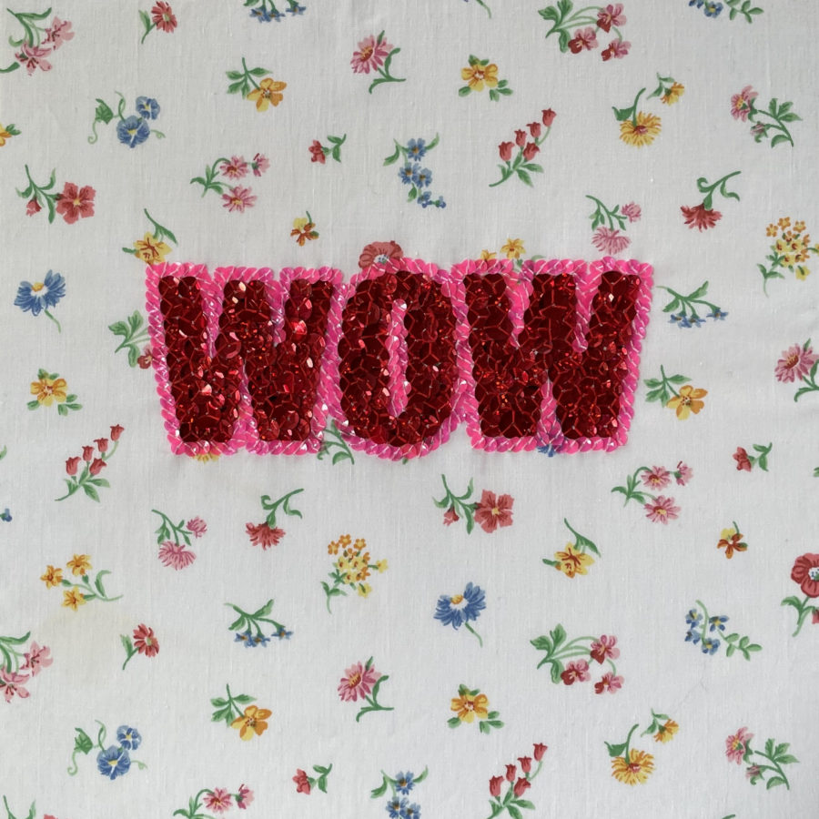 WOW, (TEXTiles)This is not an AIDS Quilt, 2023,The word WOW embroidered in sequins on a floral bedsheet
