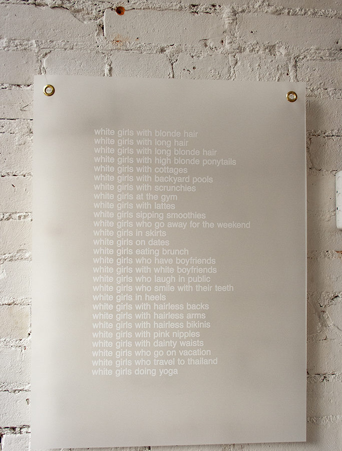 a poem of white text screenprinted on white mylar paper against a white brick wall