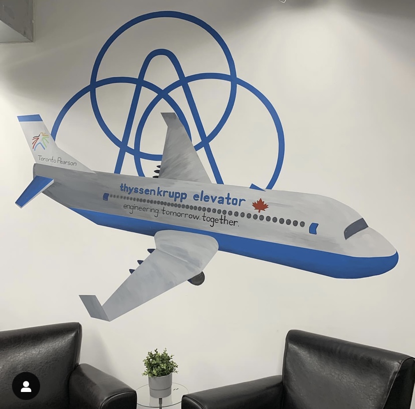 Mural at Pearson Airport, 2018. This is located in a private office, not open to the public. In the image a plane is depicted with company logo’s used as embellishments.