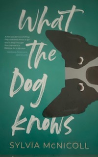 Cover with title What the Dog Knows and dog peaking in from right edge.