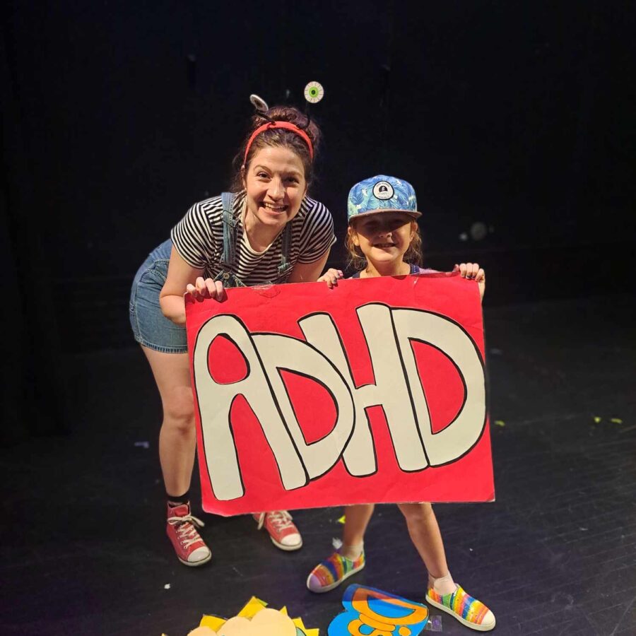 Carlyn Rhamey, The ADHD Project, holding a red sign that says 